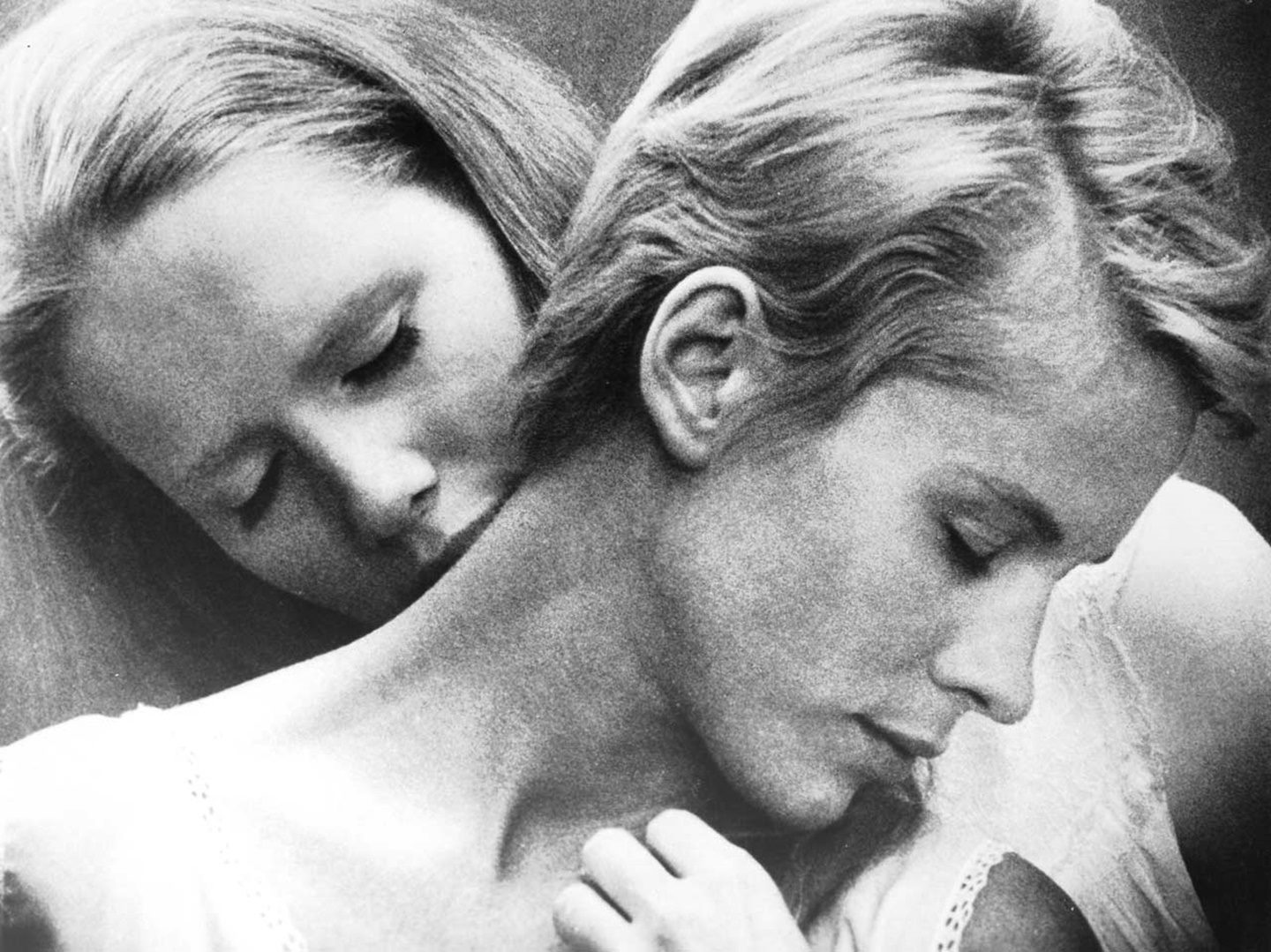 Persona di Ingmar Bergman Primo piano in bianco e nero di due donne in stretta vicinanza, una appoggiata all’altra, in un’immagine che suggerisce intimità e fusione emotiva